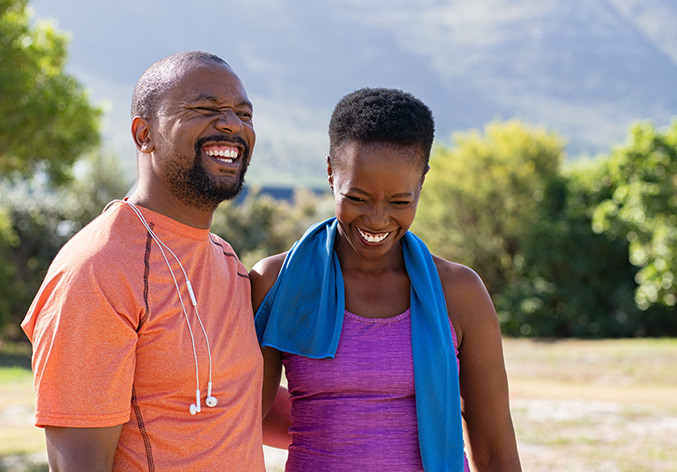 African fitness mature couple laughing at park
